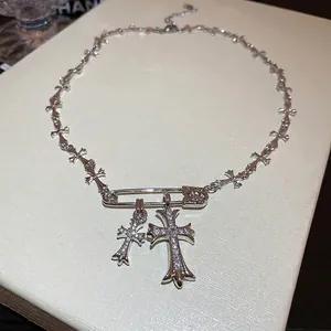Silver pin necklace with zircon crosses in gothic industrial style on beige display