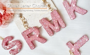 Detail of pink rhinestone letter charms with adjustable chains for bags and tumblers