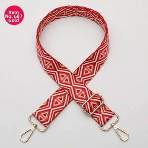 Close-up of red and white geometric jacquard strap with gold-tone metal lobster clasps