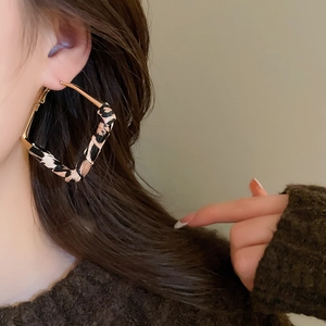Close-up of leopard print rhombus earrings with gold-plated finish on a model
