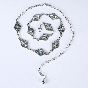 Detail of silver vintage waist chain with turquoise stones and sunburst engraving