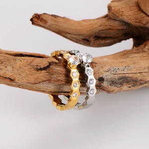 Luxe gold and silver honeycomb diamond rings displayed on a rustic wood branch