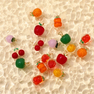 Macro shot of assorted colorful glass fruit pendants with vibrant glossy textures