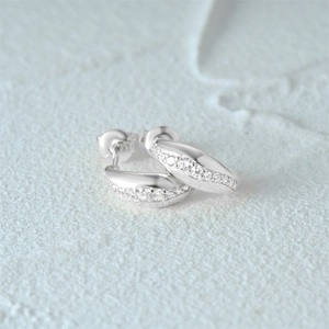 Macro shot of silver C-shaped stud earrings with sparkling cubic zirconia stones