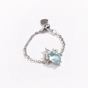 Detail of silver chain ring with blue teardrop gemstone and micro-pave zircons