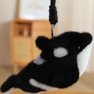 Detail of plush orca keychain featuring fluffy texture and silver metal spring hook