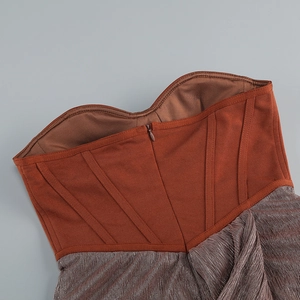 Dettaglio del corpetto in maglia caramello con tessuto metallico argento e zip invisibile