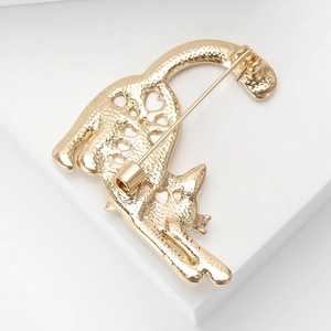 Detailed close-up of a gold-plated hollow-out cat brooch featuring artistic metal lines