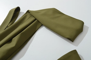 Dettaglio delle cuciture sul tessuto verde militare di questo abito lungo elegante