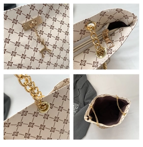Dettagli della borsa tote beige con monogramma, catena dorata e ciondolo a cervo