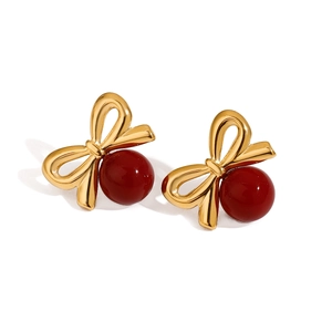 Boucles d'oreilles nœud doré avec perles en verre rouge sur fond blanc pur