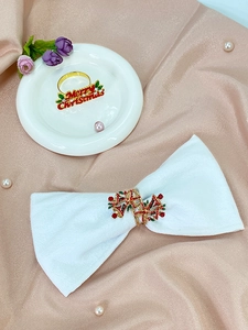 Detailed view of festive gold napkin rings with Merry Christmas text and crystal bells