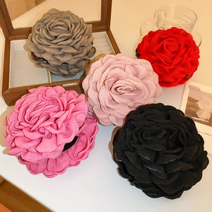Detailed view of handmade fabric flower hair clips in five elegant vintage colors