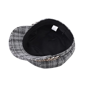 Detail view of newsboy cap lining with fabric wash tag and golden chain strap trim