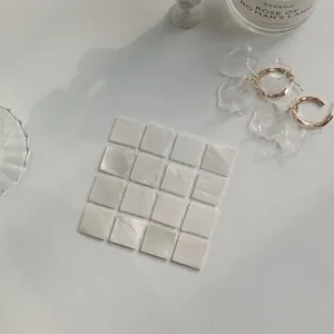 Macro detail of square mother-of-pearl mosaic coaster with 4x4 matrix iridescent shell tiles