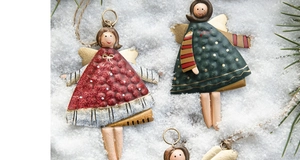 Detail of vintage hand-painted metal angel ornaments on festive snowy background