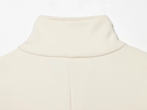Close-up of the elegant high-neck collar and fine wool texture on this beige cape coat