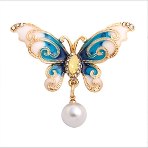 Elegant gold butterfly brooch with blue enamel wings and sparkling crystal accents