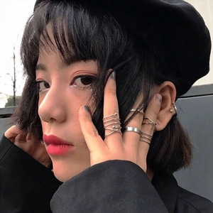Fashionable silver alloy ring set with geometric spiral designs worn by a female model