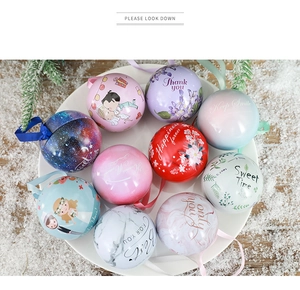 Detail view of round tinplate wedding candy boxes with ribbons on snowy pine background