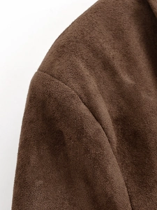 Gros plan détaillé des coutures et de la texture en daim de cette veste marron foncé