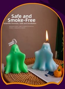 Ghost scented candles in light blue and green colors on a tray with mini pumpkins