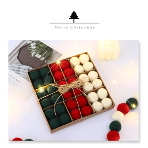 Detail of red and green wool felt balls in a craft paper box with jute twine decor