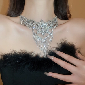 Macro detail of silver flower necklace with sparkling rhinestone tassels on model