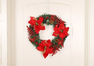 Close-up of 40cm Christmas wreath with red poinsettias, pine cones and gold leaves on a white door