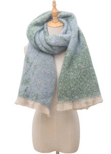 Detail of teal jacquard floral scarf showing soft plush texture and beige tassel fringes