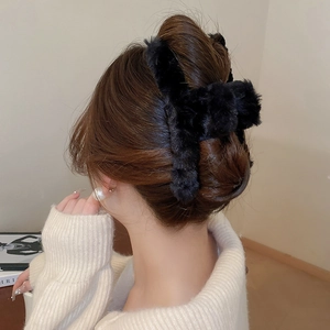 Close-up of black plush cloud-shaped hair claw clip for elegant winter hairstyling