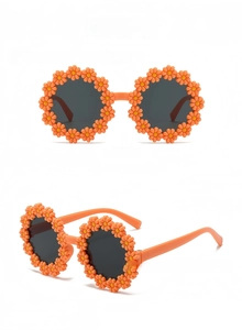 Detail view of orange daisy flower sunglasses for kids with round grey lenses