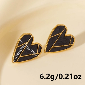 Macro detail of heart earrings showing 2.1cm height and gold texture on black enamel
