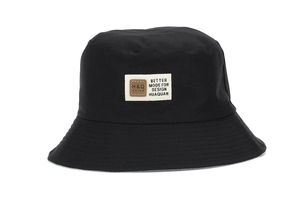 Close-up of black canvas sun hat showing rectangular label and fine stitching details