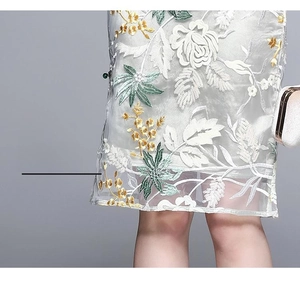 Detailed view of the embroidered hemline with floral sequins on a vintage qipao dress