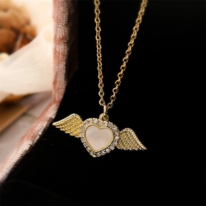 Macro shot of gold-plated winged heart pendant with shell inlay and crystals