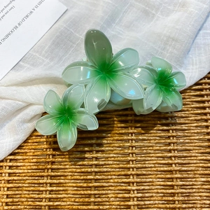 Detailed macro view of the 3D green gradient acrylic flower hair claw clip texture