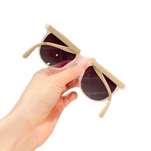 Handheld beige foldable kids sunglasses with UV400 protection on a white background