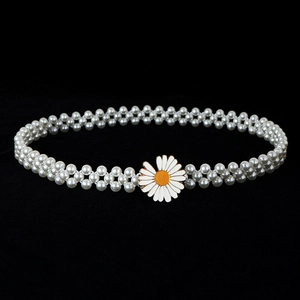 Detailed macro shot of white double-row pearl belt with elegant daisy buckle clasp