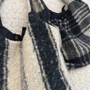 Close-up of plush striped and checkered tote bags with warm fleece texture and snap button