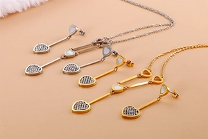 Macro detail of gold and silver heart-shaped necklace and earrings set with shell inlay