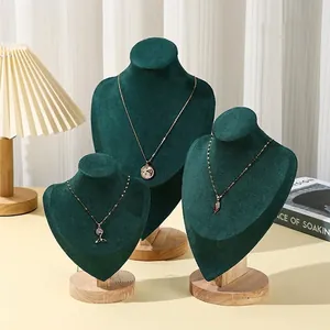 Three-piece dark green velvet necklace display stands with natural wood bases