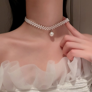 Elegant triple-strand pearl choker necklace with large center pendant on a model