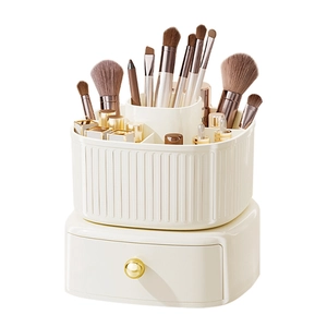 Rotating makeup brush organizer with cream white drawers and gold handles for vanity