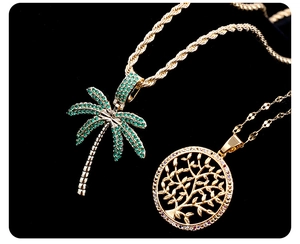 Macro detail of gold plated coconut tree and life tree pendants with micro-pave gemstones
