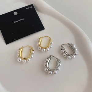 French vintage U-shaped pearl hoop earrings in gold and silver finish on ceramic tray