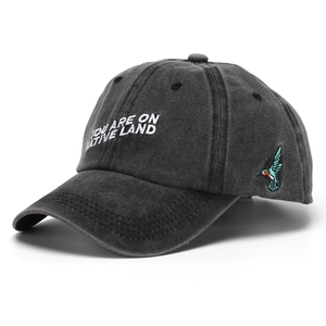 Close-up of black washed cotton baseball cap with white letter embroidery and kingfisher patch
