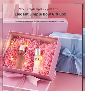 Detail of pink gift box with silk bow, decorative raffia filler and warm fairy lights