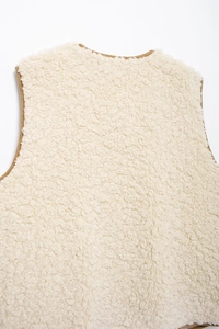 Detail of soft cream-white fleece vest showing premium plush texture and stitching