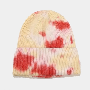 Detailed texture of tie-dye knit beanie in red and yellow with cuffed edge design